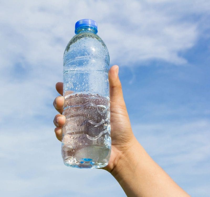 A person holding a water bottle in their hand.